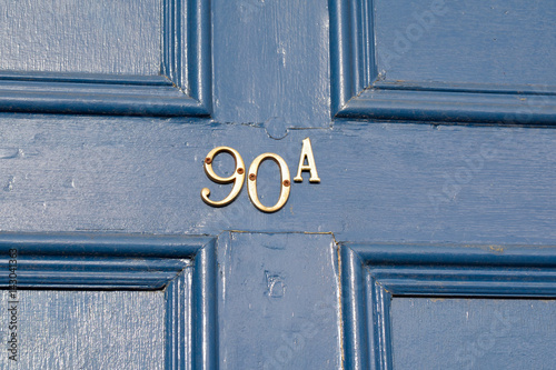 House number 90A sign on wooden door