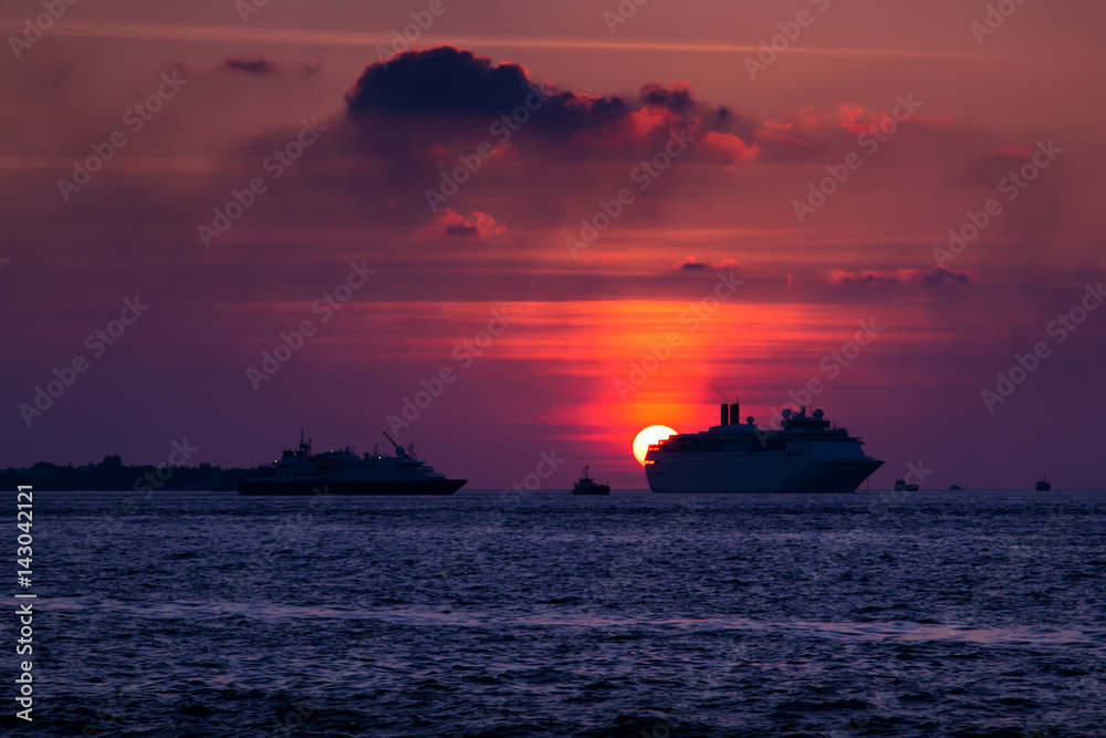 Cruise liner swimming on ocean at sunset