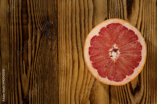 Smell of summer. Top view of a half of a grapefruit on a wooden surface copyspace on the side.