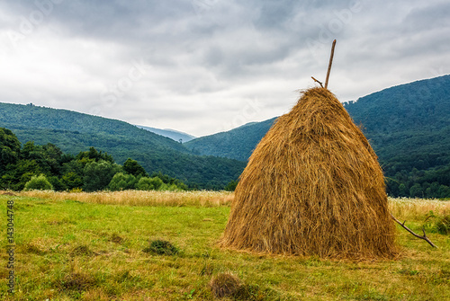 Valokuva haystack near orchard on hillside