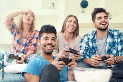 Friends having fun on the couch with video games