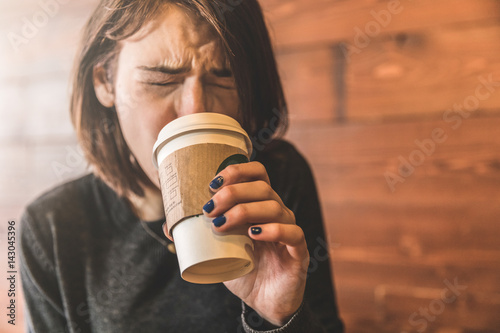 Photography Young woman drinking a coffee and burning her tongue