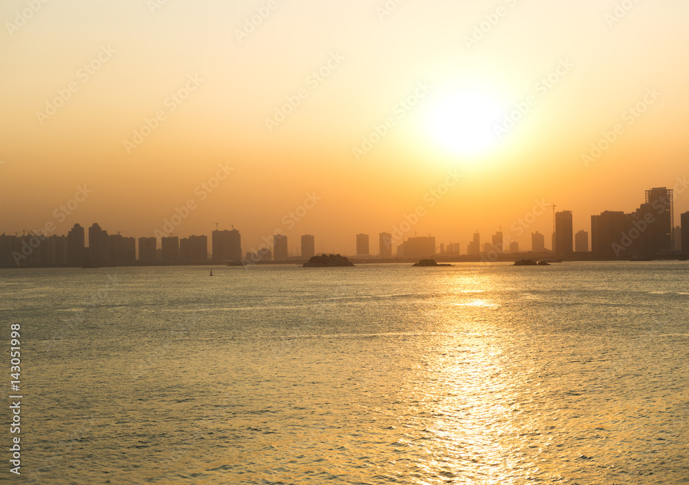 Silhouette buildings of a city with reflection in water. China Silhouette buildings of a city with reflection in water. China