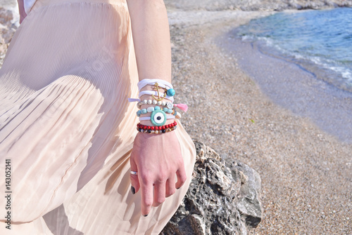 model advertises bohemian greek jewelry on the beach