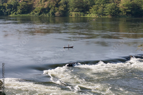 View on Victoria Nile River rapids with fishers in boat. Jinja, Uganda, Eastern Africa. 
 photo