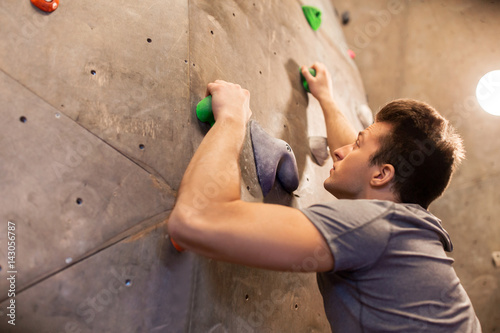 young man exercising at indoor climbing gym