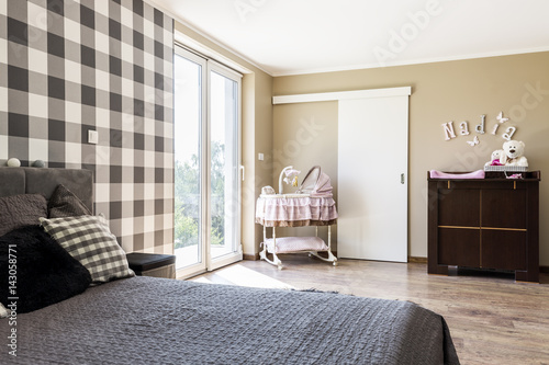 Billede på lærred Beige bedroom with a newborn's corner