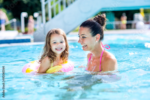 Mother and daughter in swimming pool, aquapark. Sunny summer. © Halfpoint