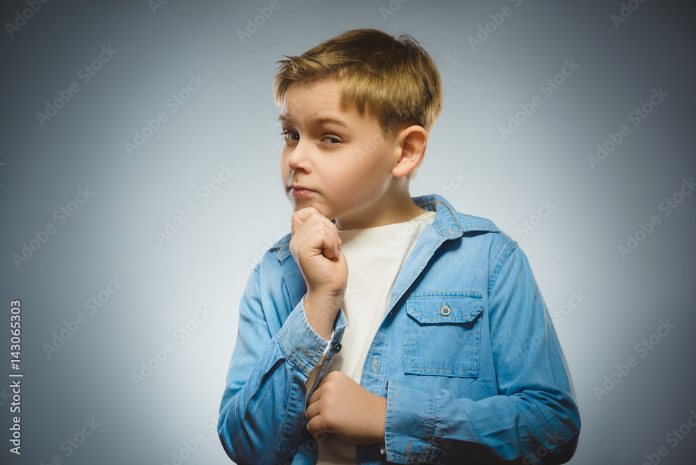 doubt, expression and people concept - boy thinking over gray background doubt, expression and people concept - boy thinking over gray background