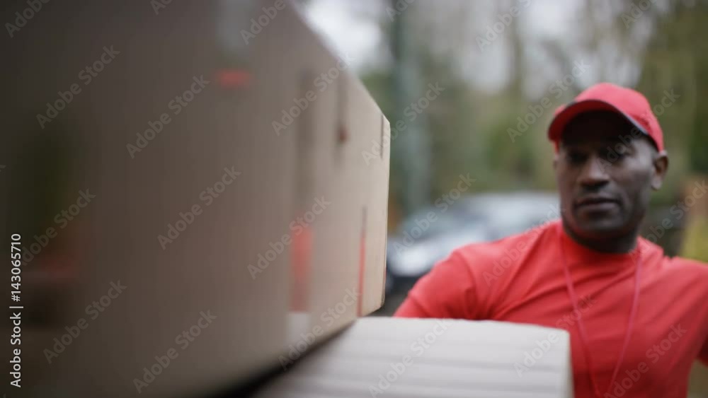 Delivery driver unloading boxes from back of van, as seen from inside vehicle Delivery driver unloading boxes from back of van, as seen from inside vehicle