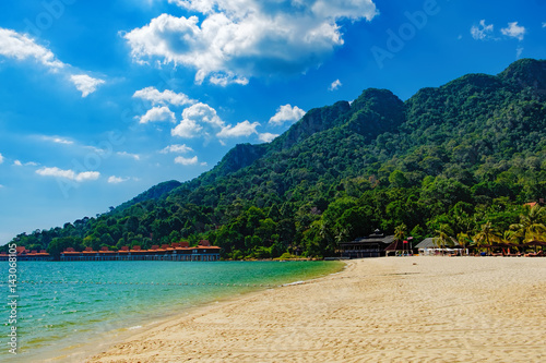 Relaxing on remote paradise beach. Tropical bungalow and luxury house on untouched sandy beach with palms trees in Langkawi Island  Malaysia.