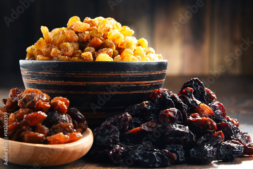 Composition with bowl of raisins on wooden table photo