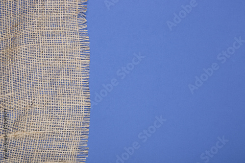 Fragment of burlap on blue background 