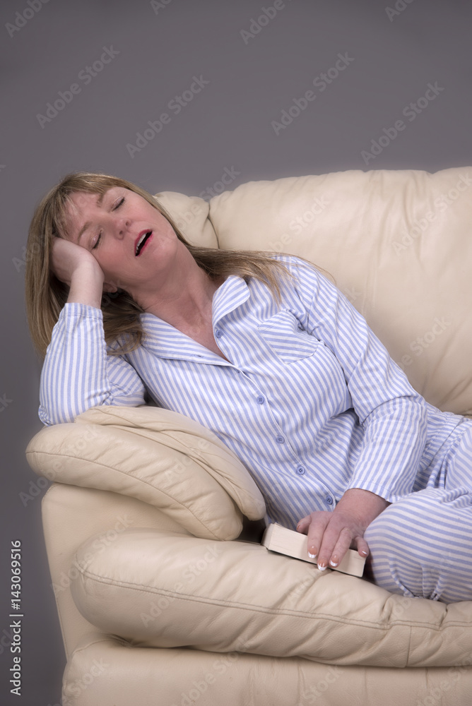 Ondergeschikt universiteitsstudent Hubert Hudson Woman wearing blue and white striped pyjamas sleeping with mouth open on a  cream leather settee Stock Photo | Adobe Stock