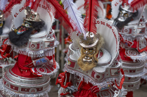 Masked Morenada dancers in ornate costumes parading through the mining city of Oruro on the Altiplano of Bolivia during the annual carnival. photo