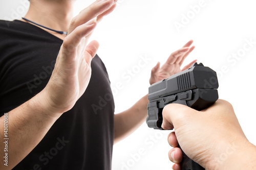 Robber with a gun robbing intimidate a man surrender. Isolated white background. Bandit steals from the male. Concept of robbery.