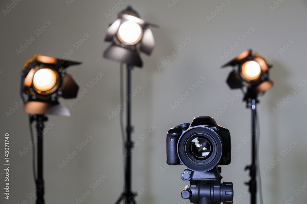Digital SLR camera and three spotlights with Fresnel lenses. Manual interchangeable lens for filming. Shooting in the interior with artificial light. Equipment for movies. Digital SLR camera and three spotlights with Fresnel lenses. Manual interchangeable lens for filming. Shooting in the interior with artificial light. Equipment for movies.