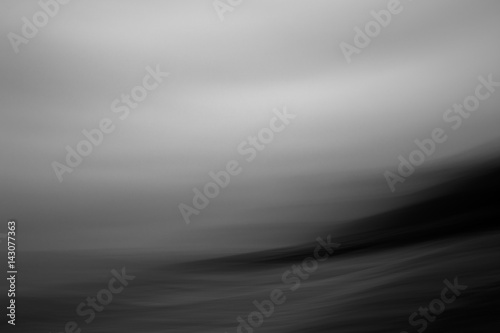 Abstract black and White image of waves crashing in over shore