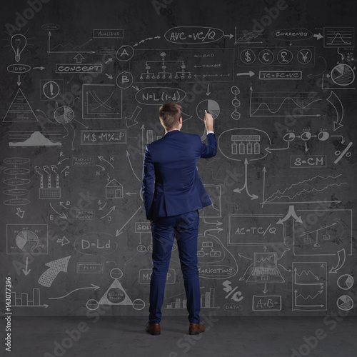 Businessman standing and drawing schemes. Business and office, concept.