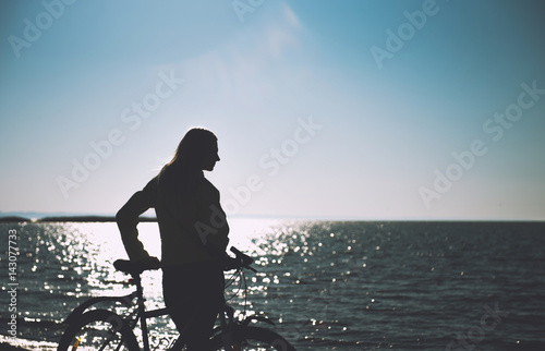 Fototapeta Naklejka Na Ścianę i Meble -  A girl on a bicycle by the sea