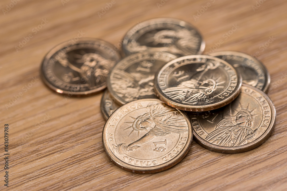 one dollar coin on wooden desk one dollar coin on wooden desk