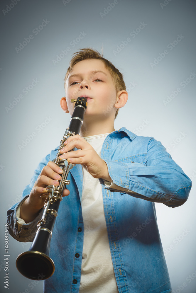 Fototapeta premium Handsome Caucasian boy play a Bassoon on grey background