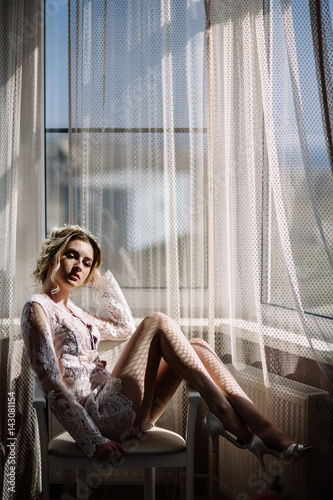 pretty girl or cute woman with long brunette hair in sexy fashionable white bodysuit and shoes on window sill on natural background, copy space photo