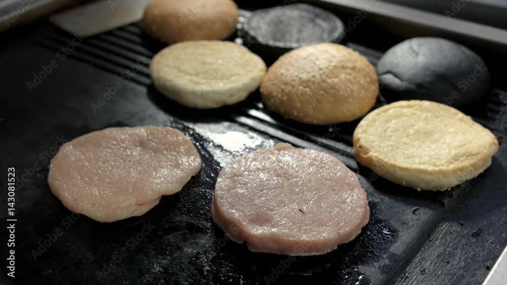 Pan with raw burger meat. Sliced sesame buns. Fry to the crisp. Pan with raw burger meat. Sliced sesame buns. Fry to the crisp.