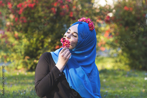 Young beautiful Muslim women enjoying sunny Spring days and smell of flowers