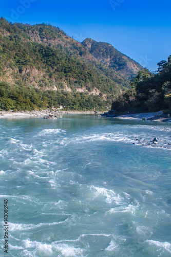 View of River Ganga and amazing blue sky at beautiful colorful day with a colorful jungles on a background houses. Rishikesh. India.