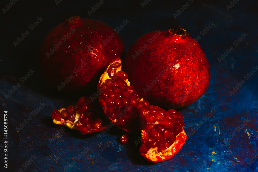 red sliced pomegranate on a blue abstraction background