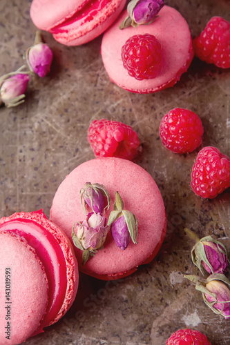 Traditional French sweets. Macaroon with raspberries on a metal tray. Dark wood background. Top view
