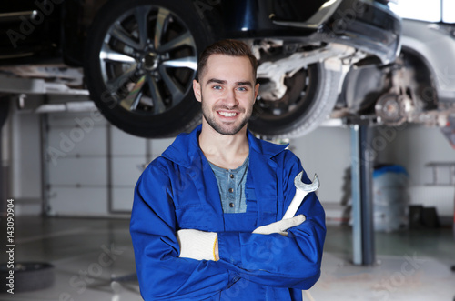 Young mechanic with tool in car service