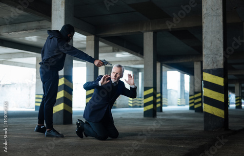 Sad scared businessman falling on his knees photo