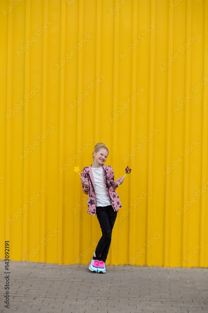 Fototapeta premium Portrait of a beautiful girl with red lips on a yellow background outdoors in summer