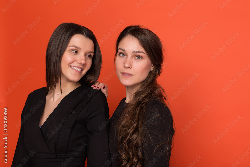 Two beautiful young women in business suits on a red background Stock ...