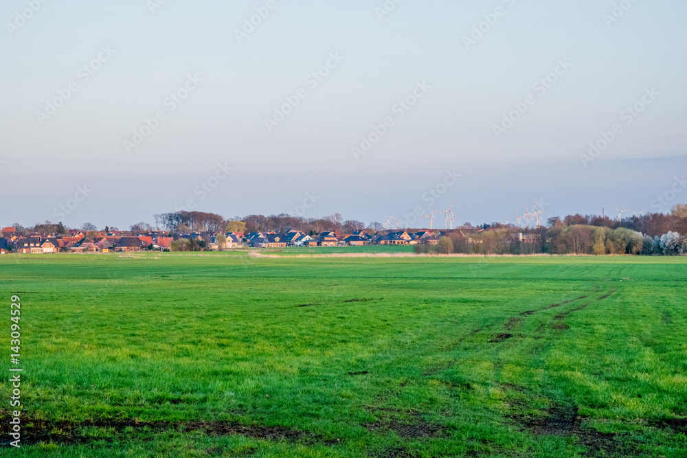 German Village behinde a green field