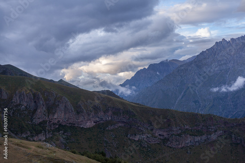 ountain panoramic view on a evening. Beautiful evening mountain landscape under bright sunset. Georgia Kazbegi