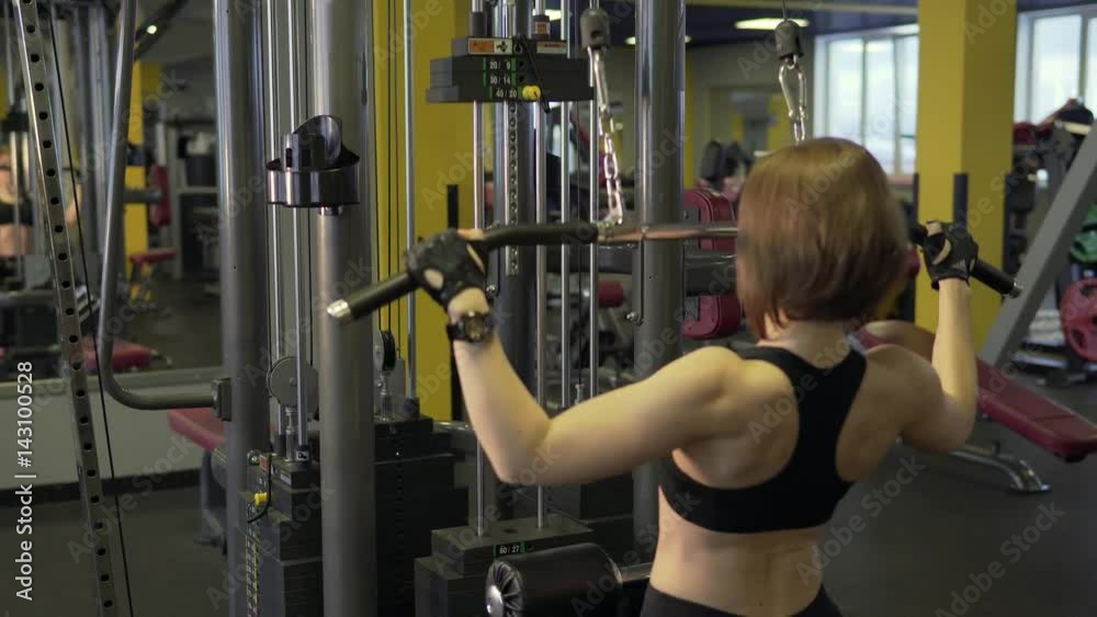 A sportswoman who came to a fitness club performs physical exercises on the Hummer Simulator. A woman can develop biceps, triceps and pectoral muscles, she likes to look slim and fit. A sportswoman who came to a fitness club performs physical exercises on the Hummer Simulator. A woman can develop biceps, triceps and pectoral muscles, she likes to look slim and fit.