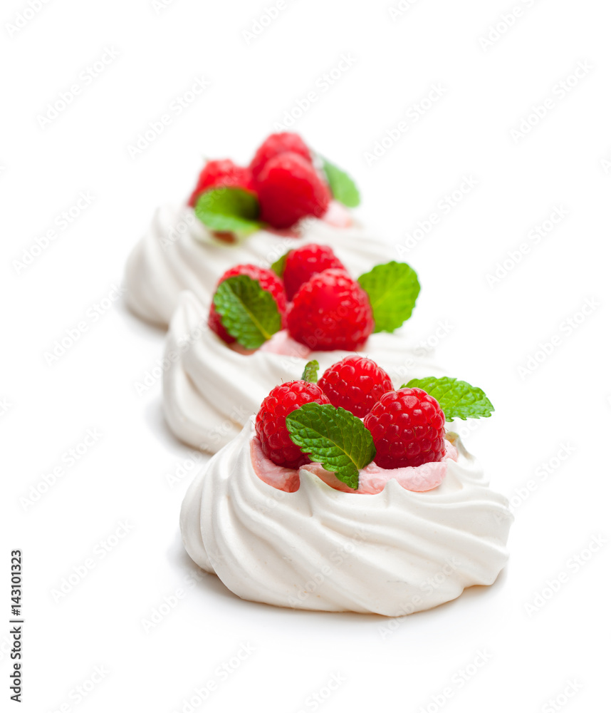 Mini Pavlova meringue nests with berries and mint on isolated on white Mini Pavlova meringue nests with berries and mint on isolated on white