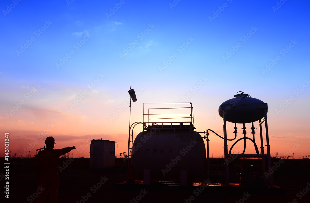 Fototapeta premium The oil tank, under the background of the setting sun