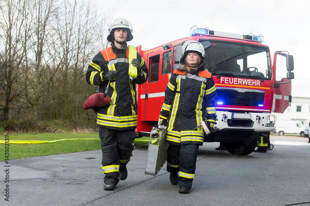 Fototapeta premium Feuerwehrmann und Feuerwehrfrau an einer Einsatzstelle