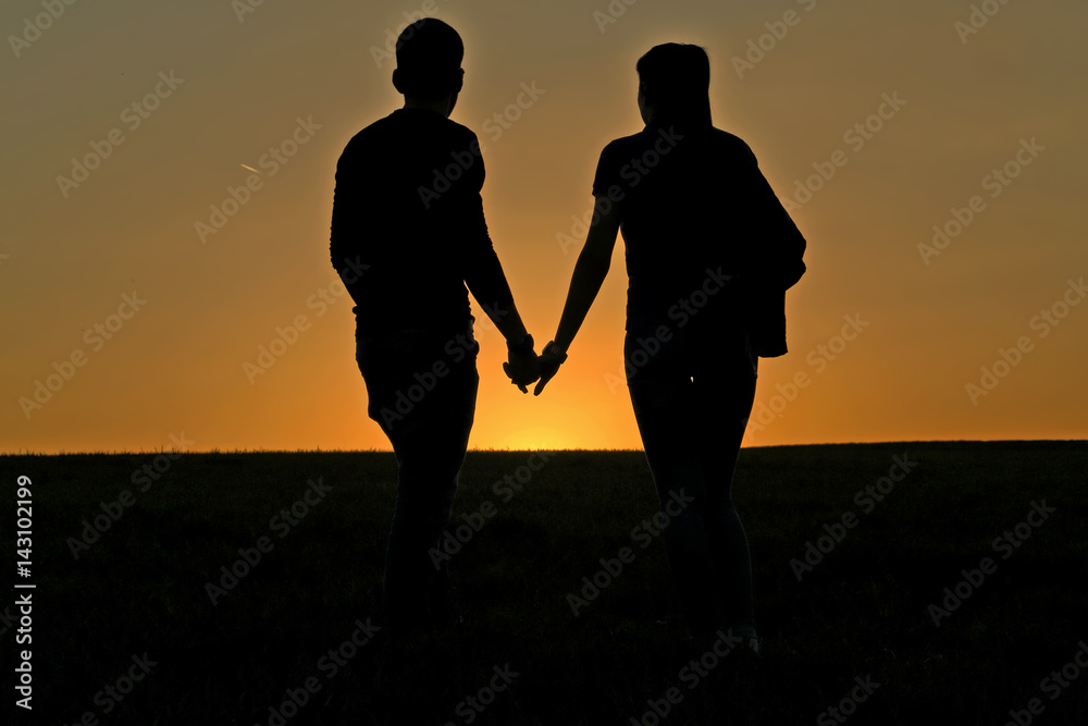 Silhouette of guy and girl on sunset