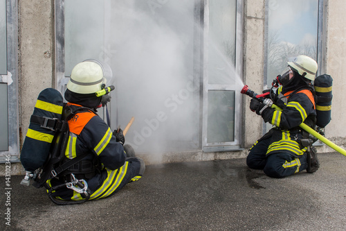 Feuerwehrmänner löschen brennendes Gebäude