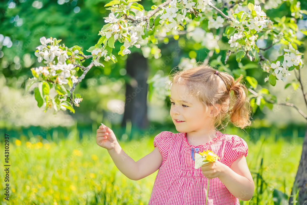Happy little girl playing in spring apple tree garden Happy little girl playing in spring apple tree garden