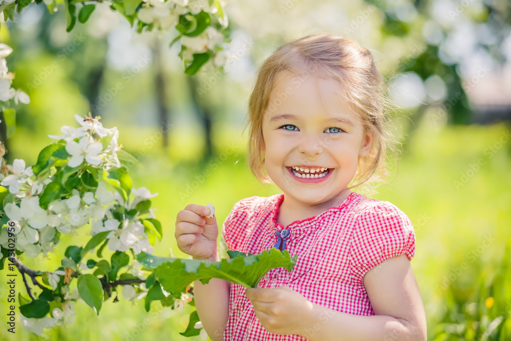 Happy little girl playing in spring apple tree garden Happy little girl playing in spring apple tree garden