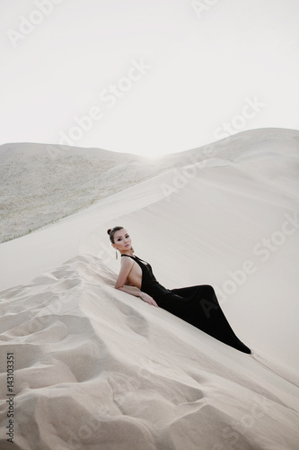 Beautiful sexy asian woman on a dune of desert photo