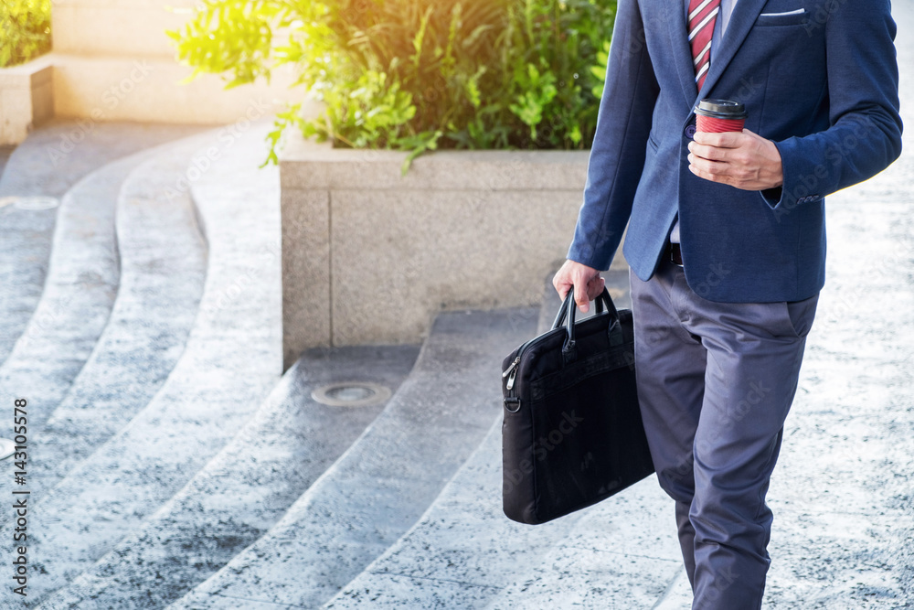 full length picture of a young business man walking forward with a ...