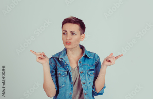 What to do, where to go? Confused brunette girl business woman pointing with hands in two different directions isolated on white green gray background. Body language, face expression, human emotions
