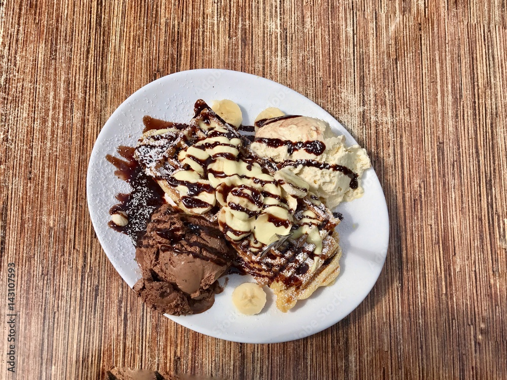 Waffle with chocolate,  vanilla ice-cream and banana from top view